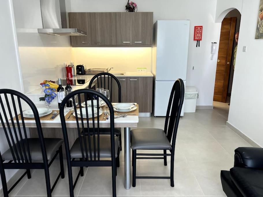 a kitchen with a table and chairs in a room at Quiet, Cosy Mellieha Apartment In Ghadira Bay in Mellieħa