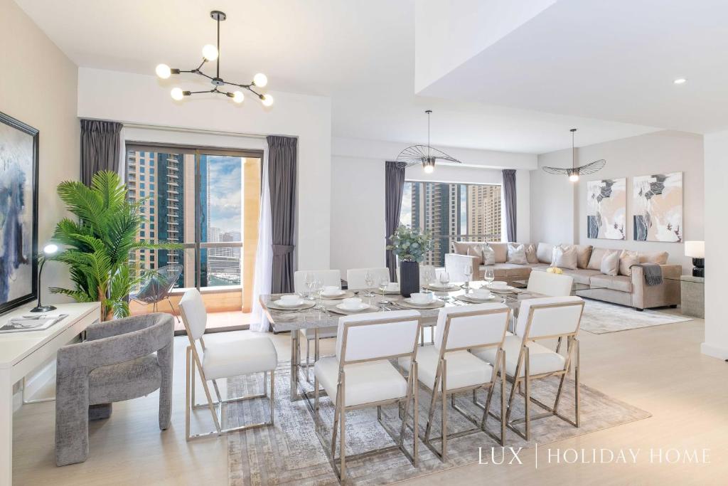 a dining room and living room with a table and chairs at LUX The Luxurious Central JBR Suite in Dubai