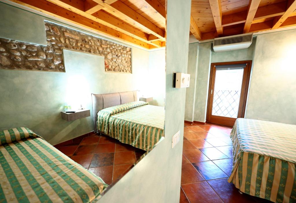 a hotel room with two beds and a window at Affittacamere Residenza Del Duca in Solferino