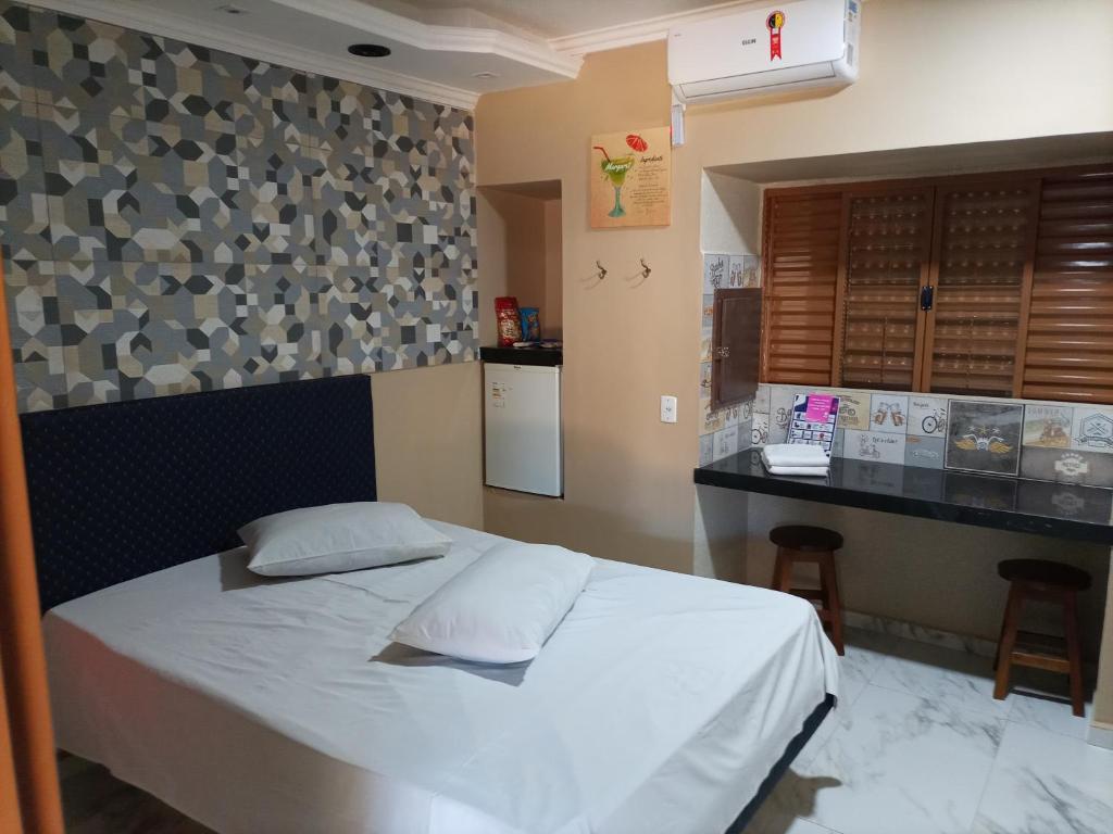 a bedroom with a white bed and a counter at Motel Vip Olimpia in Olímpia