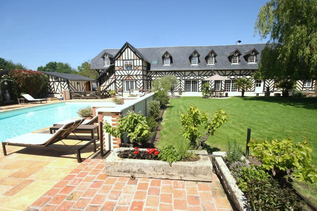 a large house with a swimming pool and a yard at Manoir de la Croix-Sonnet in Trouville-sur-Mer