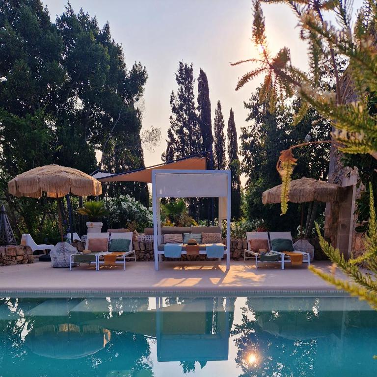 a pool with chairs and a gazebo next to a pool at Las Fincas de Annie in Felanitx