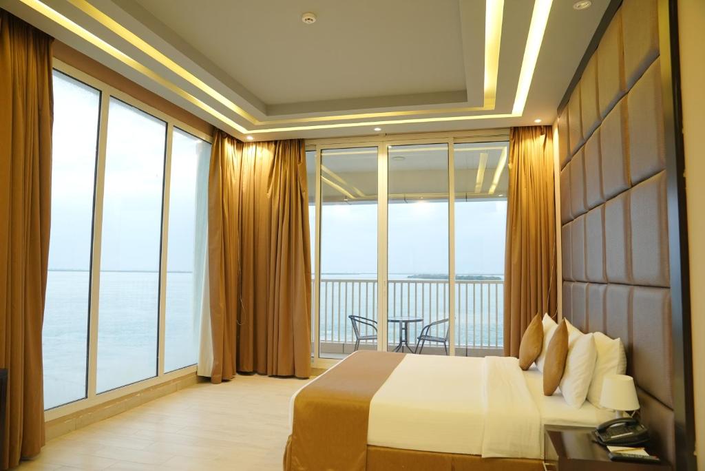 a bedroom with a bed and a large window at Flamingo Beach Hotel in Umm Al Quwain