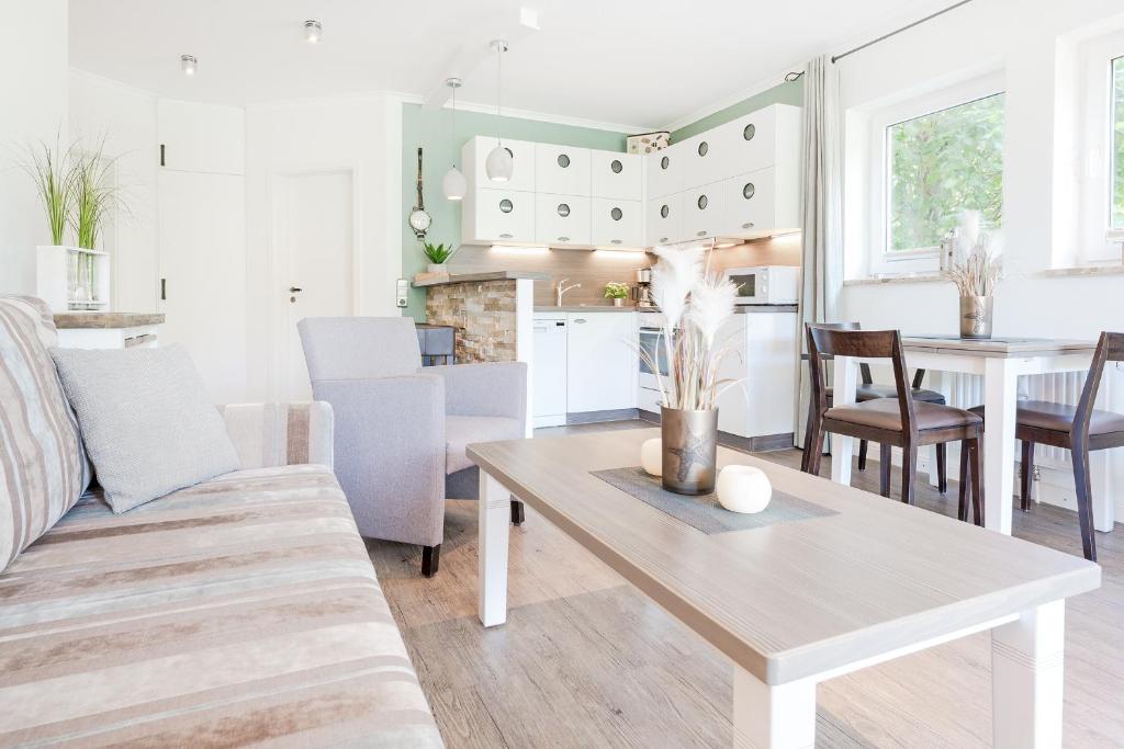 ein Wohnzimmer mit einem Sofa und einem Tisch in der Unterkunft Ferienwohnung Deichblick mit Terrasse m Kaiserhof 1 in Kellenhusen