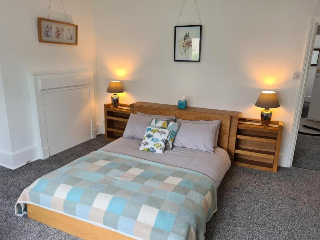 a bedroom with a bed with two night stands and two lamps at Gorgeous Sea View Apartment 5 mins To The Beach in St. Leonards