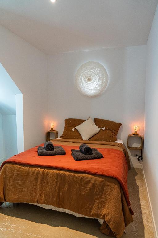 a bedroom with a bed with two towels on it at Maison Arthur in Aigues-Mortes