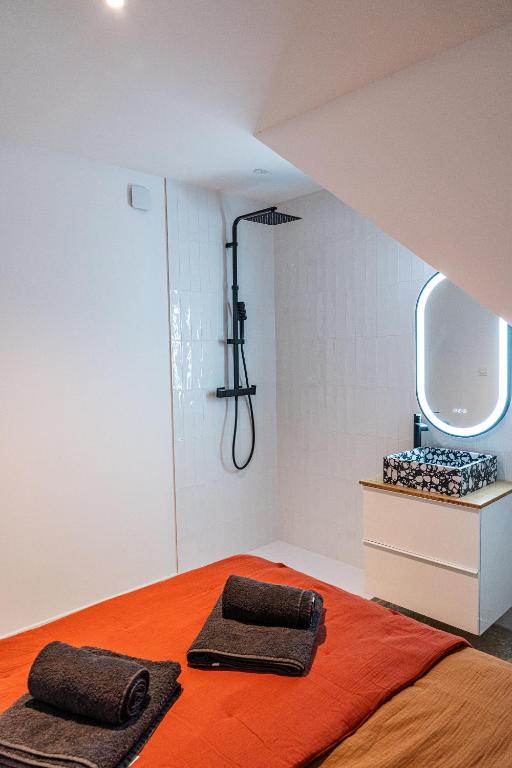 a bedroom with an orange bed and a mirror at Maison Arthur in Aigues-Mortes
