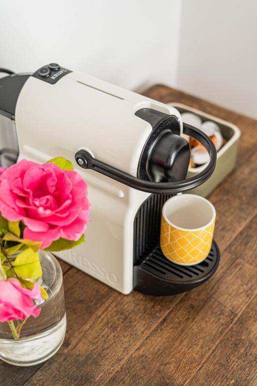 a toaster sitting on a table with a cup and flowers at Maison Arthur in Aigues-Mortes