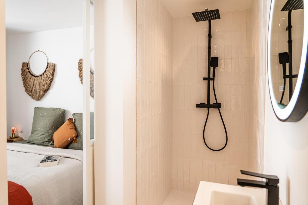 uma casa de banho com um chuveiro e um lavatório. em Maison Arthur em Aigues-Mortes