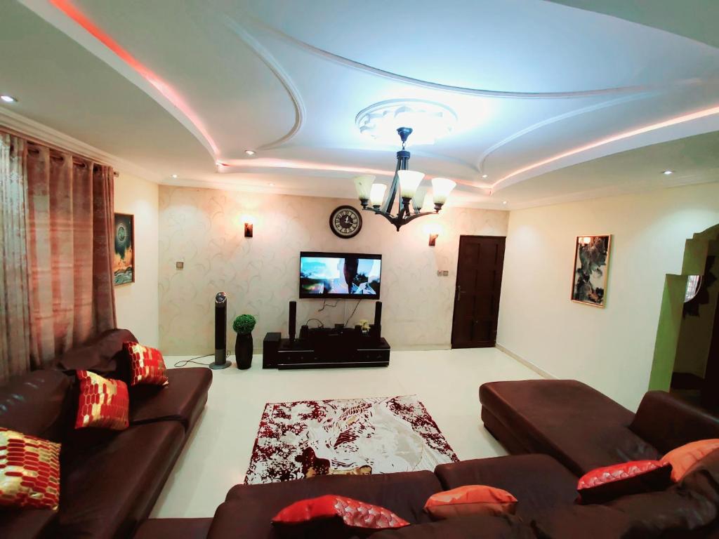 a living room with two couches and a tv at Stylish and Spacious 3Bed Flat ShortLet Apartment in Abuja