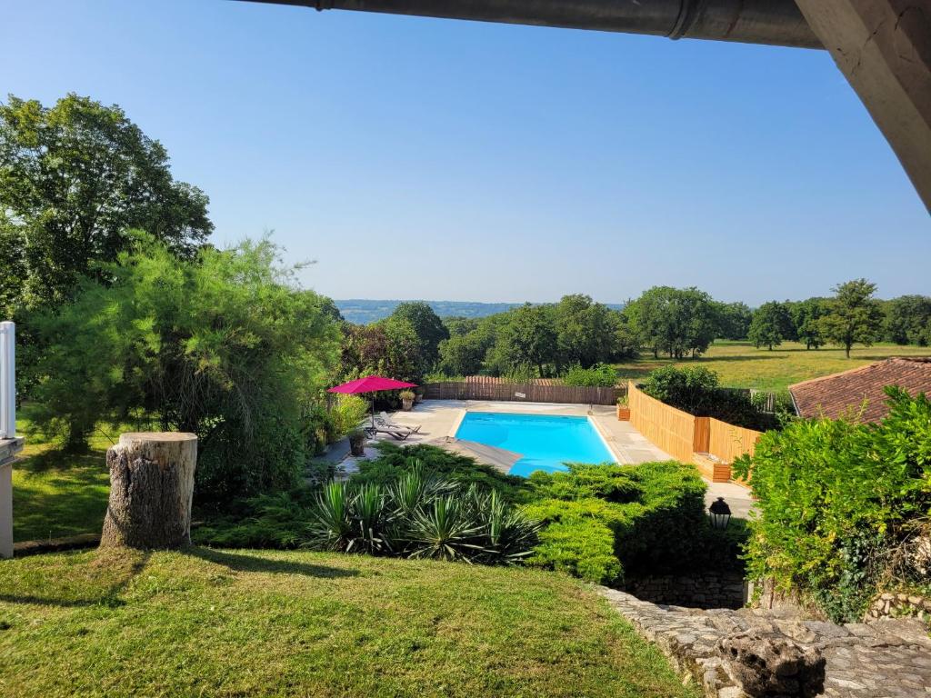 una piscina en un patio con jardín en L'Oasienne, en Lissac et Mouret