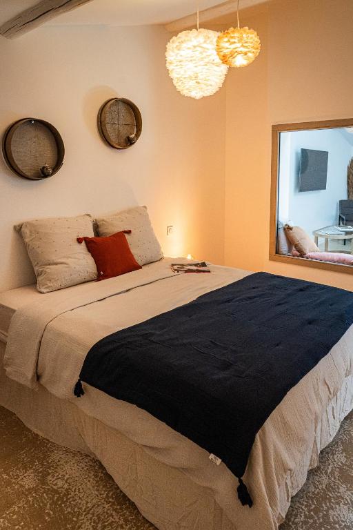 a bedroom with a large bed with pillows and a window at Maison Arthur in Aigues-Mortes