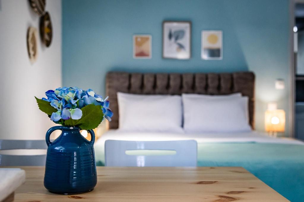 a blue vase with blue flowers on a table in a bedroom at Venus Studio in Stafylos