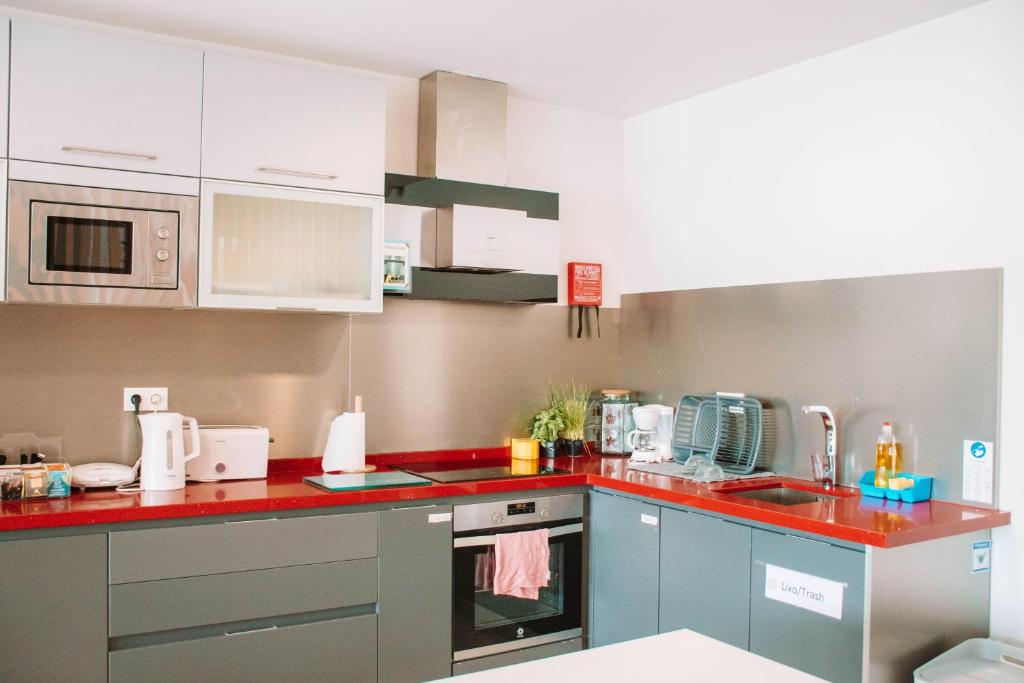 a kitchen with a red counter top at Arca Nova Guest House & Hostel Caminha in Caminha