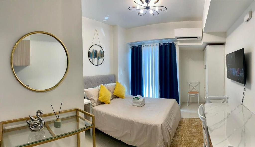 a bedroom with a bed and a mirror and a table at INSPIRIA TOWER CONDOMINIUM 1911 in Davao City