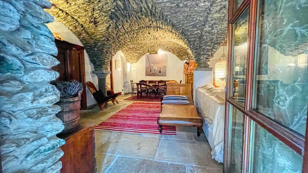 a room with a stone building with a table and benches at Appartamento Jouvenceaux 50 - Affitti Brevi Italia in Sauze dʼOulx