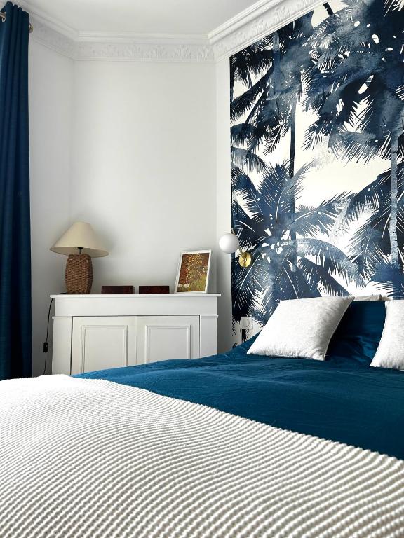 ein Schlafzimmer mit einem Bett mit einer blau-weißen Wand in der Unterkunft Appartement charmant et lumineux ! in Boulogne-Billancourt