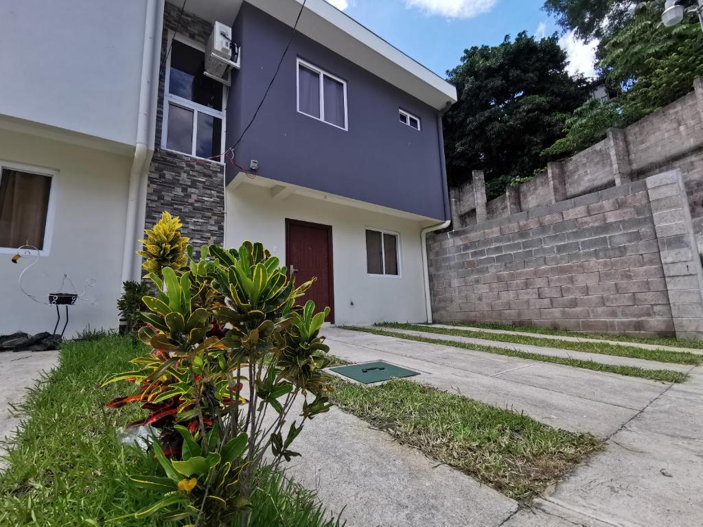 a house with a purple door and a wall at Casa El Cipres Residencial Privada in Santo Tomás