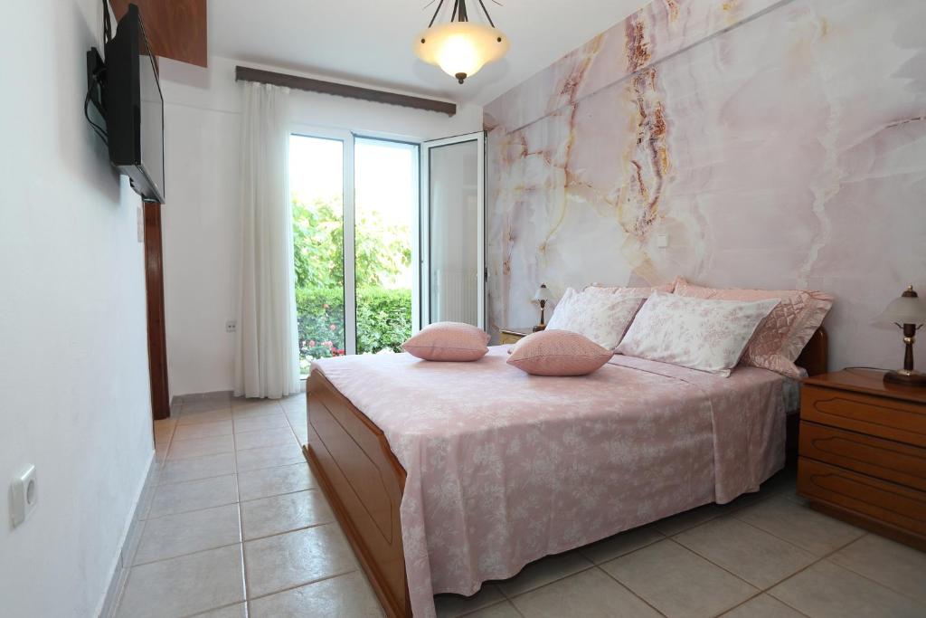 - une chambre dotée d'un lit avec des oreillers roses dans l'établissement Rose House, à Réthymnon