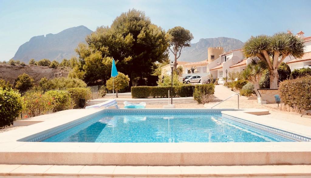 a swimming pool in a yard with trees and houses at VIP Alfaz del Pi in Alfaz del Pi