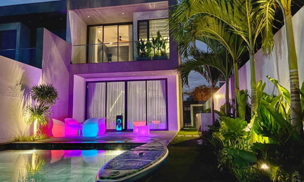 a house with a swimming pool with purple lighting at PLAYA Villa in Sanctuary Resort - 100m from Private Beach - New 2023 in Ho Tram