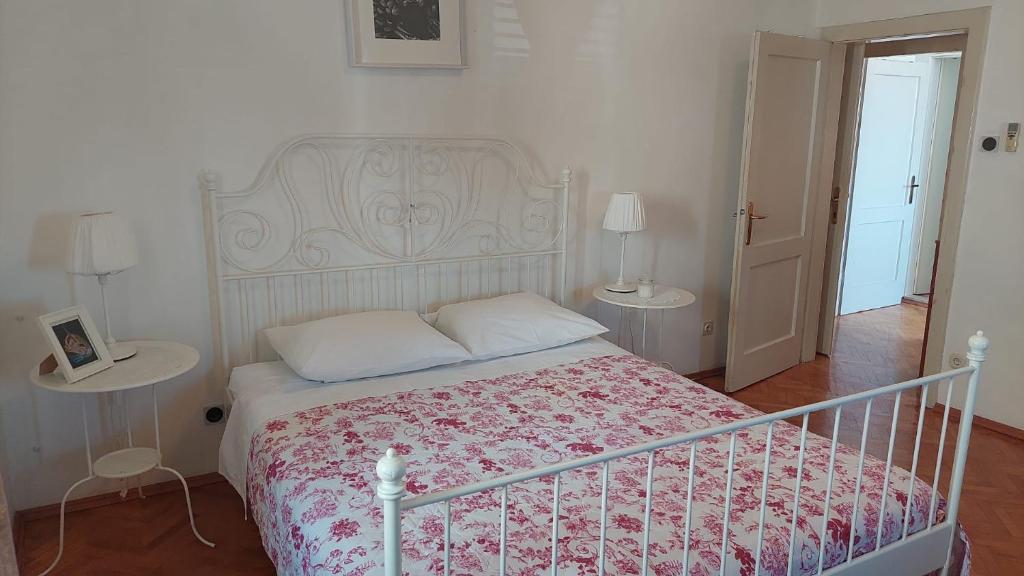 a bedroom with a bed and two tables with lamps at PORT on riva with parking and sea view in Makarska