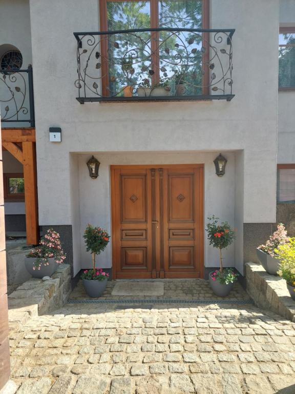 a house with a wooden door and two potted plants at la Brigitte in Hennigsdorf