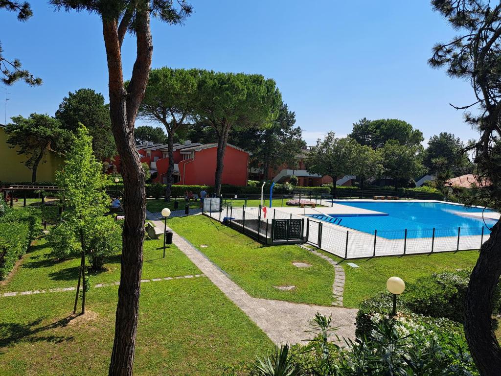 uitzicht op een zwembad in een park bij Adriella apartments in Bibione