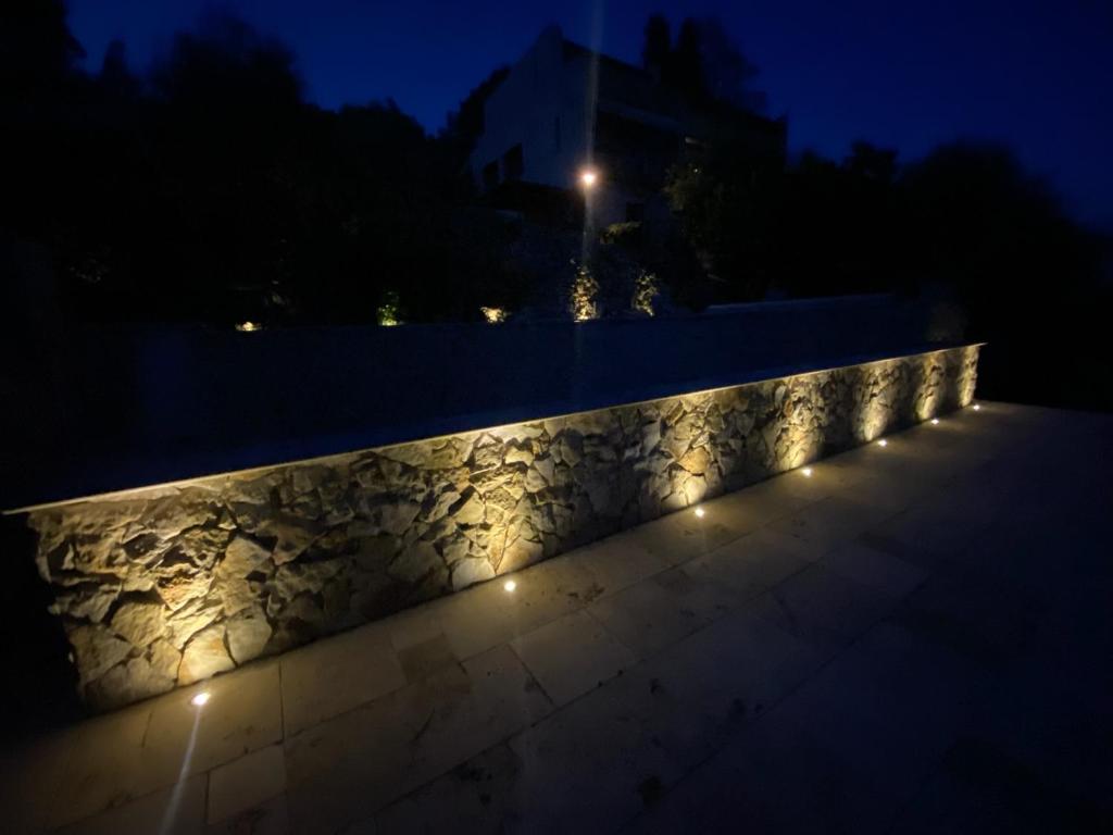 una pared de piedra con luces por la noche en Dieu L'Amour - Molinard en Châteauneuf