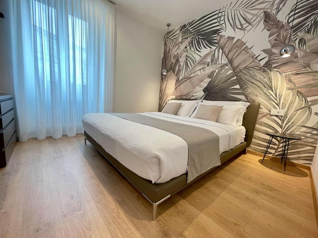 a bedroom with a large bed with a plant mural at Clavis Luxury Apartments in Chiavenna