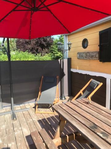 a picnic table and a red umbrella on a patio at Lou Bohème in Le Briou