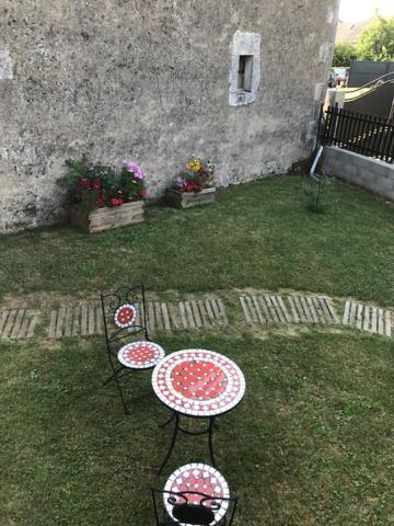 two tables and chairs in the grass in a yard at Lou Bohème in Le Briou