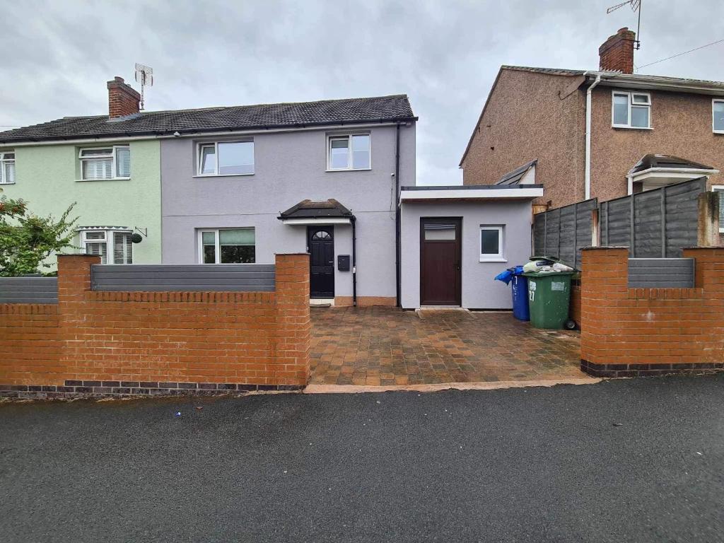 a house with a brick fence in front of it at Adina s House in Rugeley