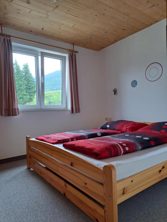 Un dormitorio con una cama grande con almohadas rojas. en Ferienwohnung Schwarzbach en Leogang