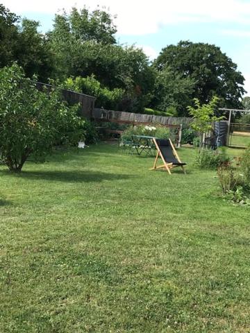 a yard with a picnic table in the grass at Lou Bohème in Le Briou