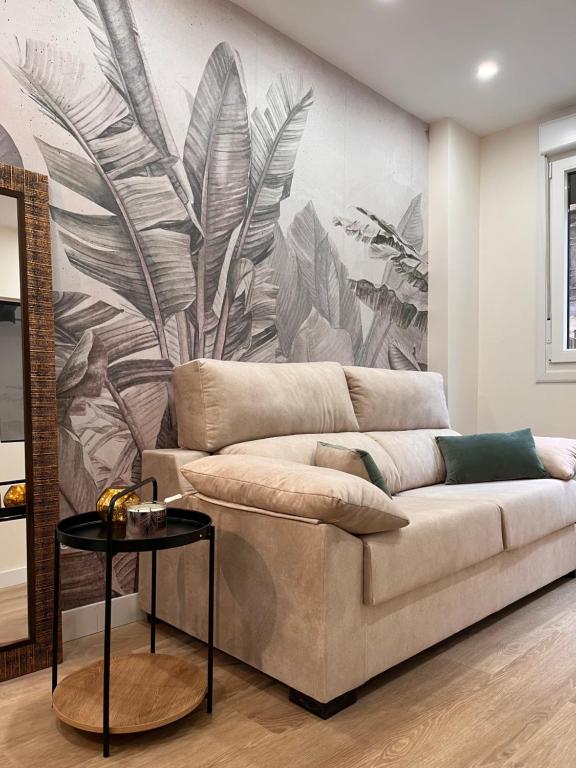 a living room with a couch and a wall mural at KALA apartamentua Parking gratuito cercano in Bermeo