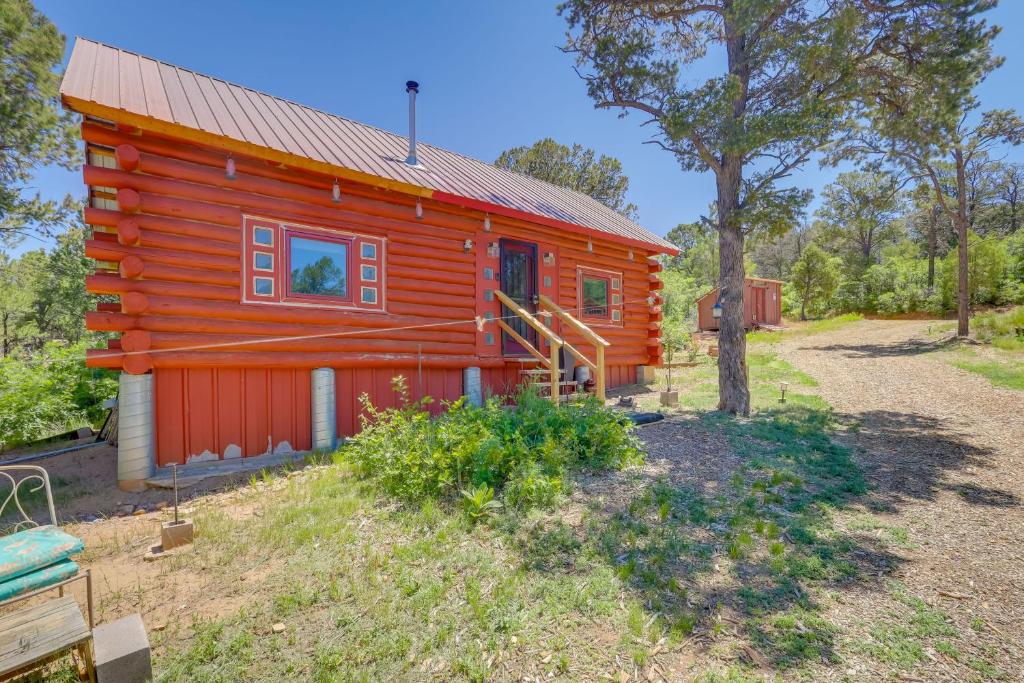 a red cabin with a tree in front of it at Pet-Friendly and Secluded Regina Cabin! in Regina