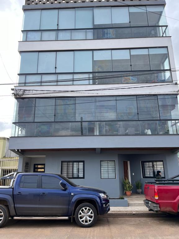 a blue truck parked in front of a tall building at Apart JJ - Departamento céntrico - amueblado a estrenar in Paso de los Libres