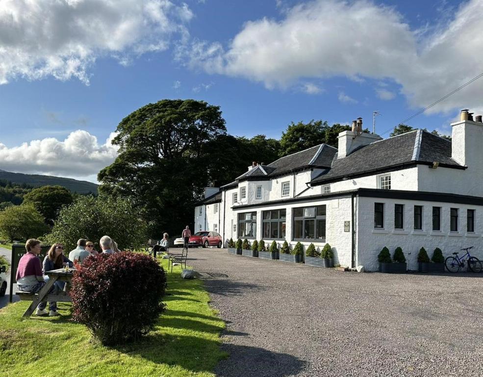 a group of people sitting outside of a building at The Strontian Hotel in Strontian