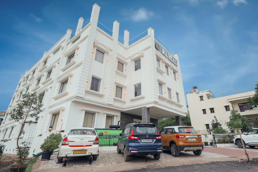 a white building with cars parked in front of it at Revaas Lake View Boutique Hotel in Udaipur