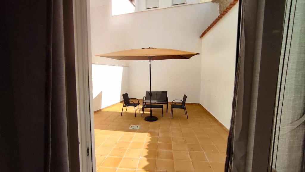 - une table et des chaises avec un parasol dans la chambre dans l'établissement Cuchillos de la fonseca, 