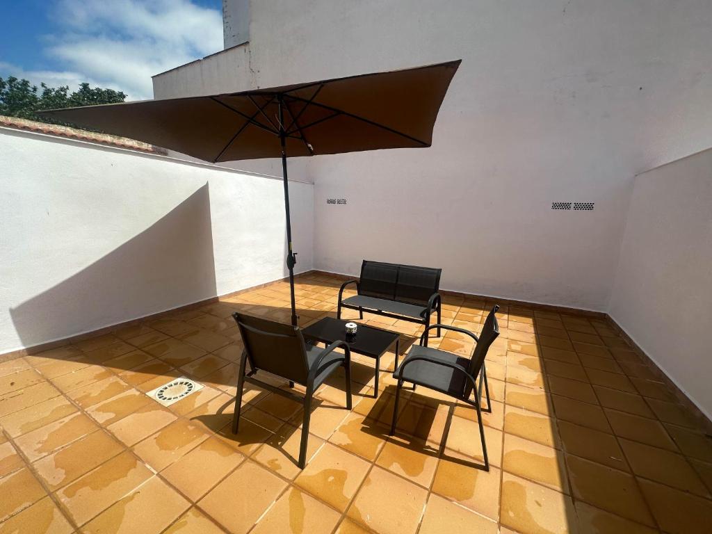 un patio con mesa, sillas y sombrilla en Flat 'Hoces del Cabriel' in Casas de Moya, 