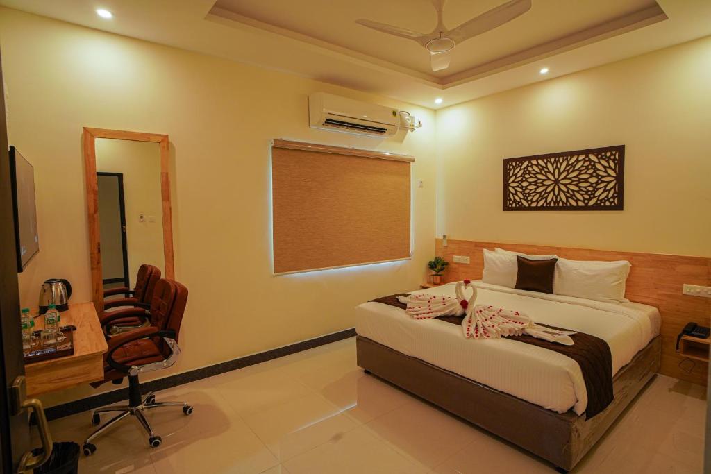 1 dormitorio con cama, escritorio y silla en TPC Camphor en Tiruchchirāppalli