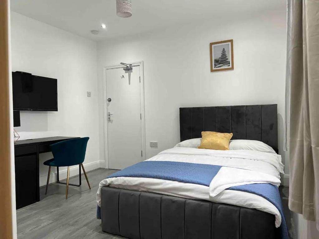 伊爾福德的住宿－Inviting 2-Bed Apartment in Ilford，一间卧室配有一张带桌子和椅子的床