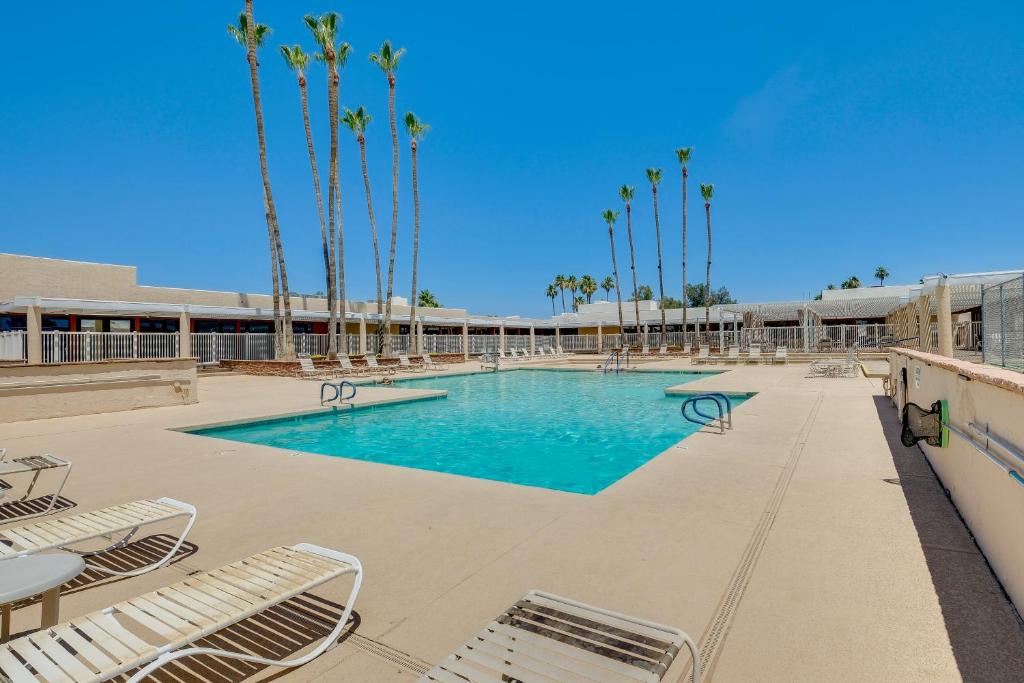 una piscina con tumbonas y palmeras en Sun Lakes Vacation Rental BBQ Grill and Pool Access, en Sun Lakes