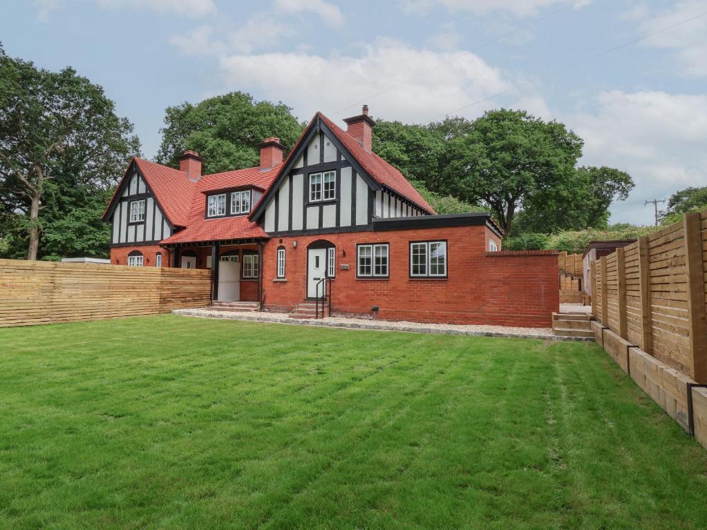 a large house with a green lawn in front of it at 2 Golf Links Cottages in Northwich