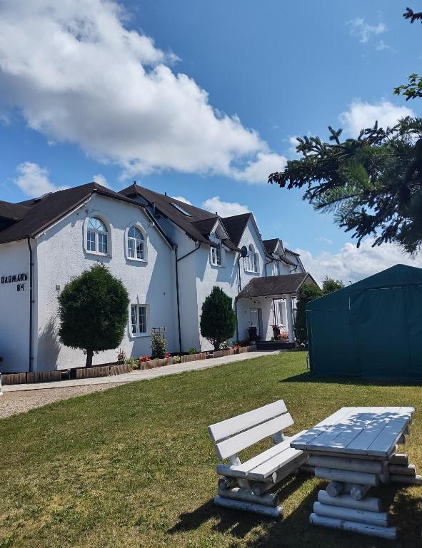 a white house with a picnic table in the yard at DAGMARA in Łeba