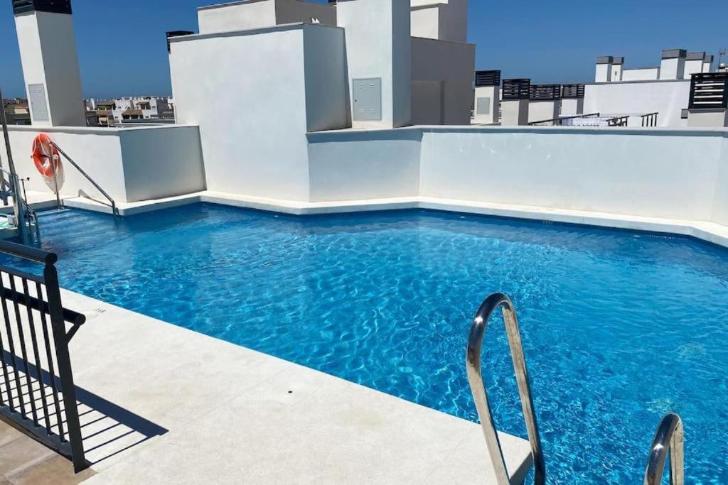 a large swimming pool on a building with blue water at Nautilus 3 - Elegante Apartamento para 6 con Piscina, Wifi y AC en Rota in Rota