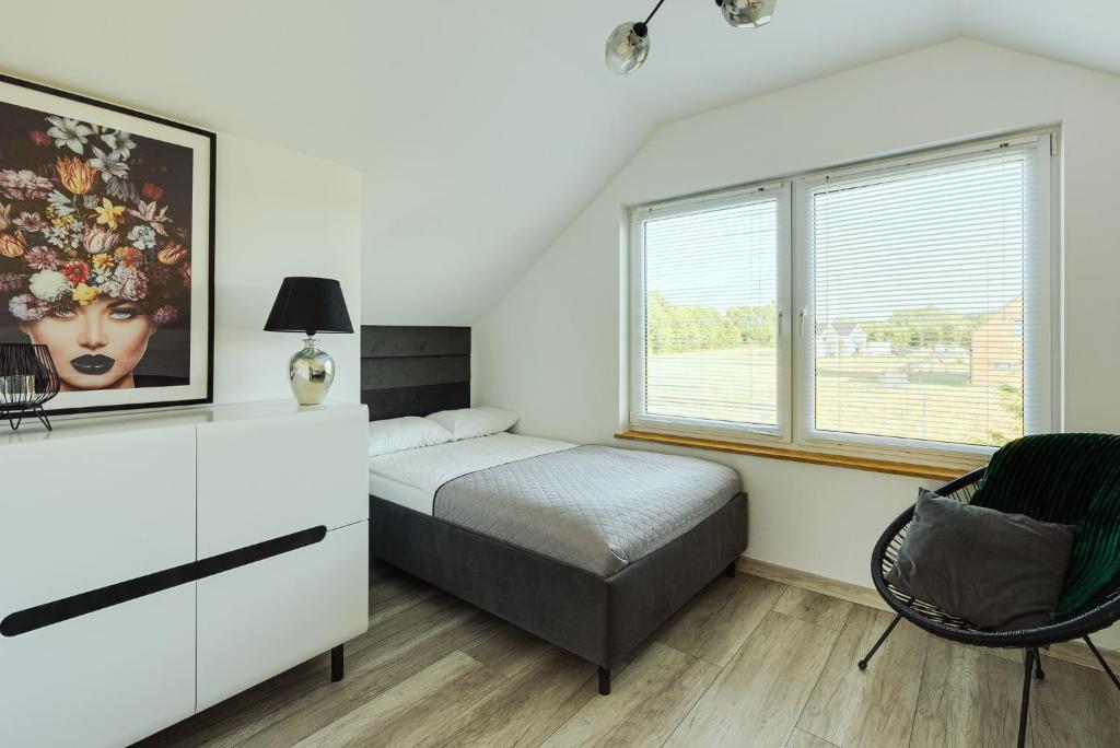 a bedroom with a bed and a large window at Domek Zielony Zakątek in Słajszewo