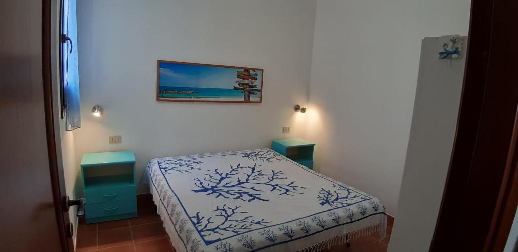 una piccola camera con un letto e una foto appesa al muro di Casa Serena a San Vito lo Capo